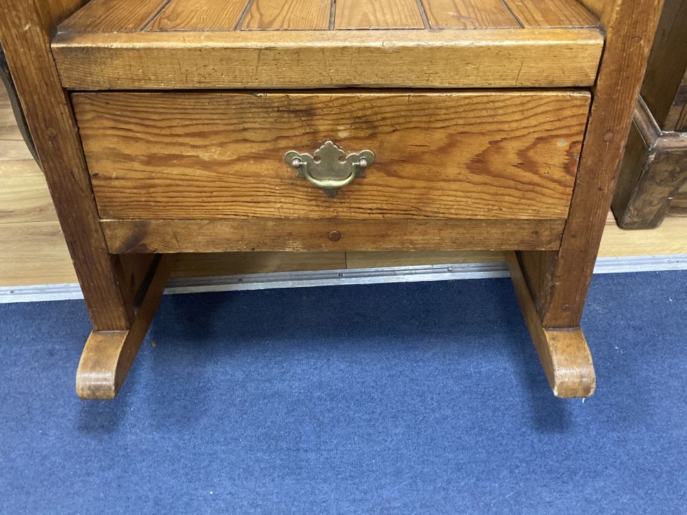 A pitch pine rocking armchair, width 66cm, height 111cm